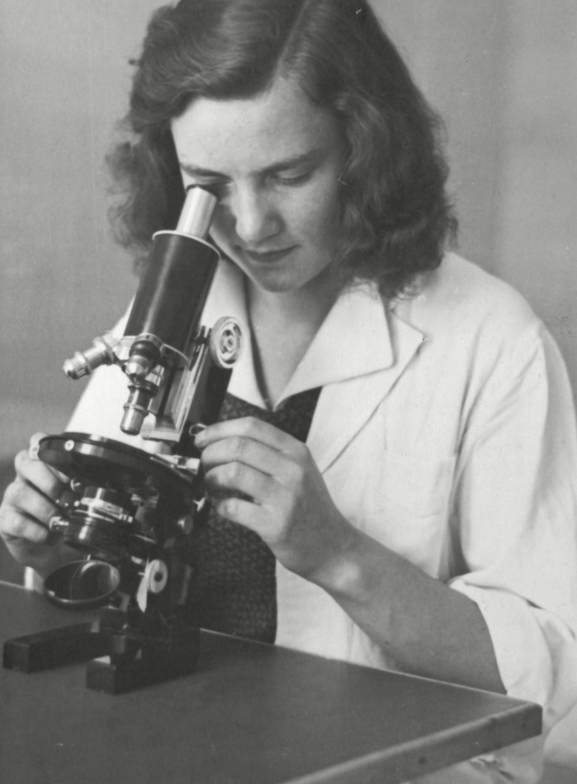Scientist peers into her microscope