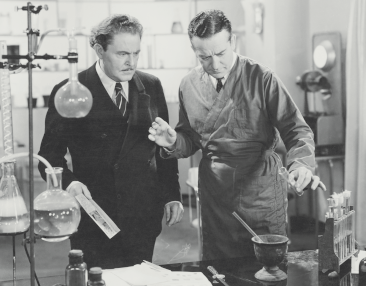 Two scientists, one about to pour a test tube into his mortar